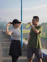 young asian couple having rest after jogging in the morning photo