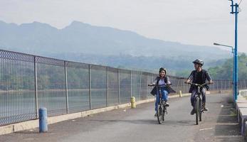 young asian couple ride bicycle together go to work photo