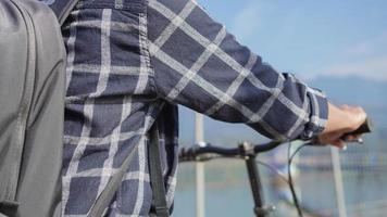 asian young man with backpack riding bicycle on street photo