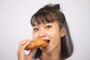 Asian woman eating bread isolated on white background photo