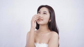 Chica asiática con maquillaje riéndose mano cubriendo la boca aislado sobre fondo blanco. foto