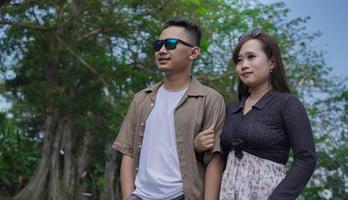 young couple holding hands and walking together in the park photo