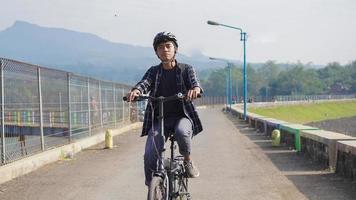 asian youth riding bicycle to work photo