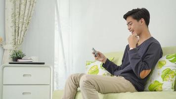 young man wins game play on smartphone at home photo