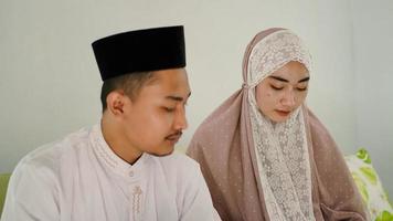 Asian Muslim couple praying together at home photo