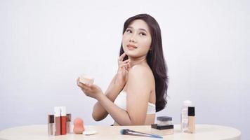 beautiful asian smile doing makeup isolated on white background photo