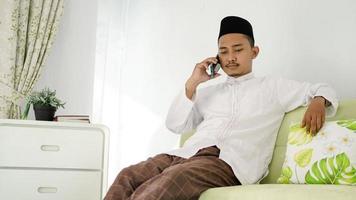 asian muslim man sitting on the phone photo