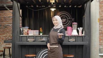 beautiful waitress gesturing happily at cafe booth container photo