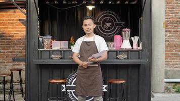Asian man barista ready to open a container themed shop photo