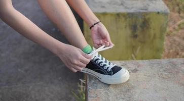 Young Asian woman has prepare her shoes before running and jogging in the morning photo
