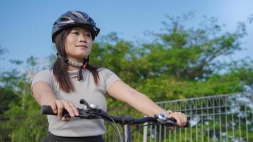 young asian woman enjoying cycling in summer morning photo