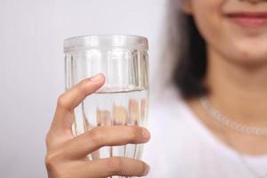 Asian woman holding glass of water on white background isolated photo