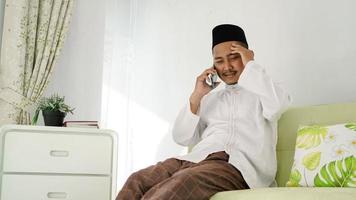 asian muslim man sitting on the phone photo