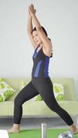 asian woman practicing yoga at home doing muscle warm up photo