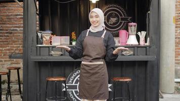 beautiful smiling waitress ready to welcome customers at the cafe booth container photo
