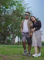 young couple holding hands and walking together in the park photo