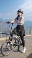 young asian woman enjoying cycling when stopped in summer morning photo