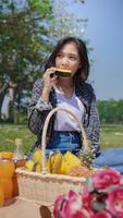 joven asiática comiendo sandía de vacaciones en el parque foto