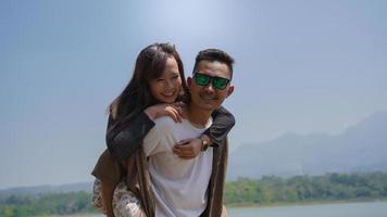 happy young couple holding their partner on the lake at spring photo