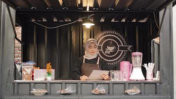 beautiful asian waitress reading menu list at cafe booth container photo