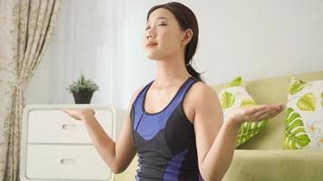 mujer asiática practicando yoga en casa con plena concentración foto