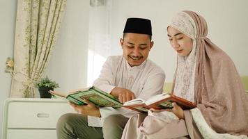 Muslim husband helping his wife read the Quran photo