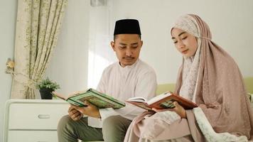 Muslim husband guides his wife to read the Quran photo