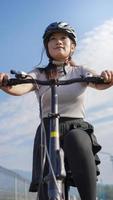 joven mujer asiática en bicicleta en verano foto