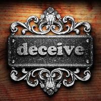 deceive word of iron on wooden background photo