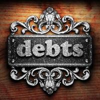 debts word of iron on wooden background photo