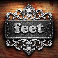 feet word of iron on wooden background photo