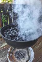 Glowing barbecue charcoal fire smoke when turning on barbecue Norway. photo