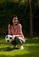 A young mother plays football in the evenings with her children. photo