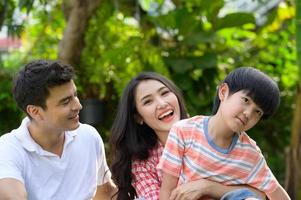 A happy young family spends time playing together in the garden at the front of house the vacation. photo