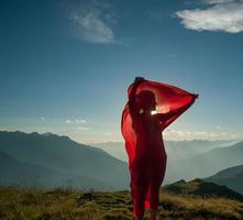 Woman wrapped in a red scarf in the wind photo