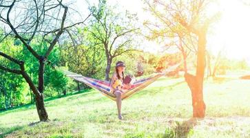 Woman sitting on a hammock reading a book photo