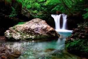 Coolness of a beautiful pool of water created by a waterfall photo