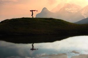 chica corre en las montañas con una bufanda en la mano al atardecer foto