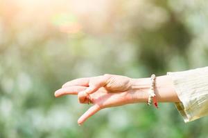 mano en posición de yoga en la naturaleza foto