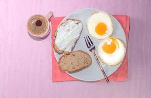 Rebanada de pan de huevo frito en un plato con café espresso foto