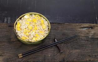 Fried rice with egg in bowl on wood background. photo