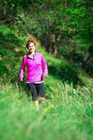 Girl with a cheerful smile runs in the nature photo