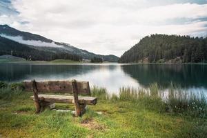 Tourist bench in front of an alpine lake photo