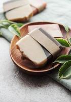 Handmade soap bars and green leaves photo