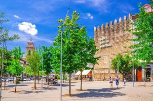 Guimaraes, Portugal - June 24, 2017 Torre de Alfandega old medieval tower Aqui Nasceu Portugal and Jardins da Alameda gardens park with green trees in Guimaraes city photo