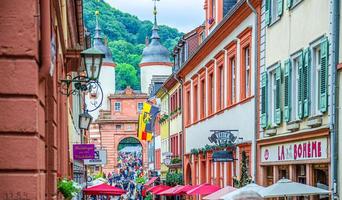 Barcelona, Spain - June 11, 2017 people tourists walking down pedestrian street with typical german houses with colorful walls in Heidelberg Old town historical centre