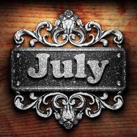 July word of iron on wooden background photo