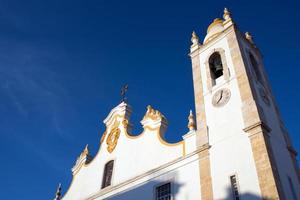 iglesia blanca tradicional con campanario alto. vista desde abajo. portimão, algarve, portugal. foto