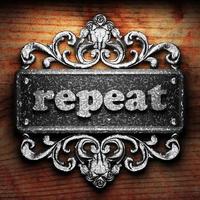 repeat word of iron on wooden background photo