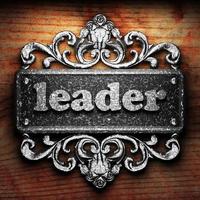 leader word of iron on wooden background photo